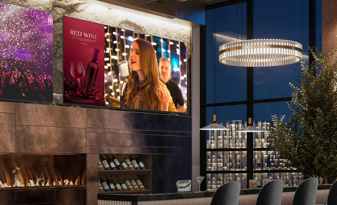 Two displays are installed in the luxurious wine bar. One shows a concert scene, and the other displays two images in one screen showing both a red wine commercial advertisement and a female singer singing.