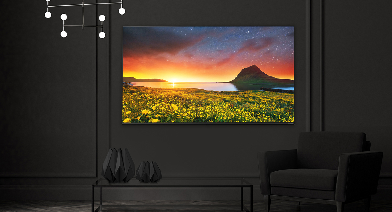 A TV hanging on the hotel wall shows a vivid and bright screen.