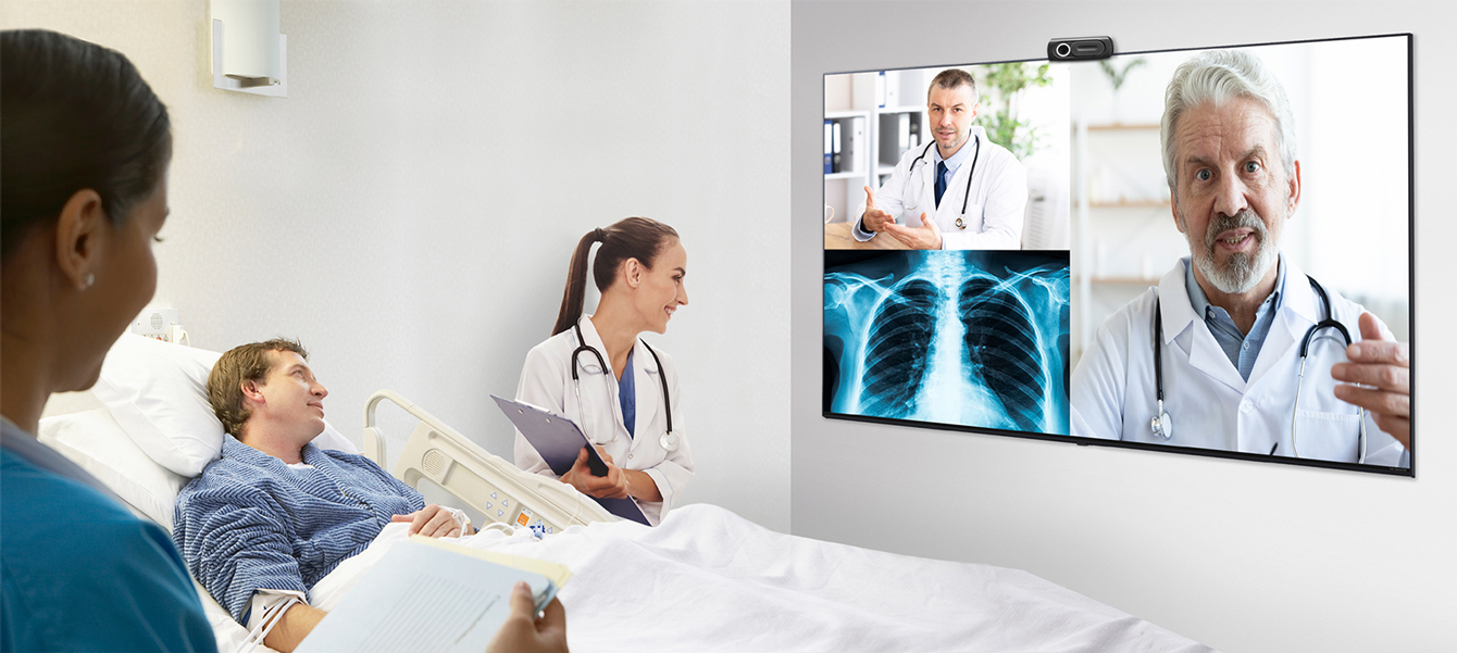 Patients and nurses in the hospital room are communicating remotely with the doctor via TV.