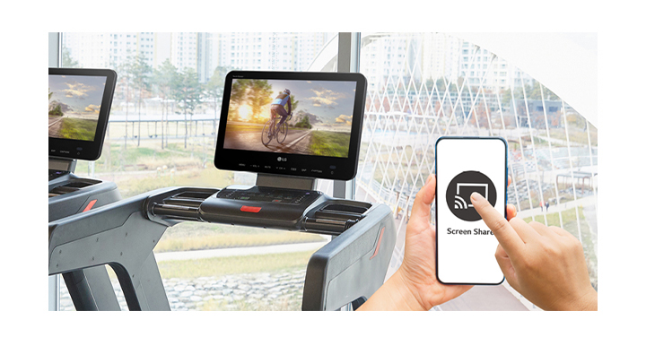 A smart phone screen is being shared wirelessly on a TV installed on a treadmill.