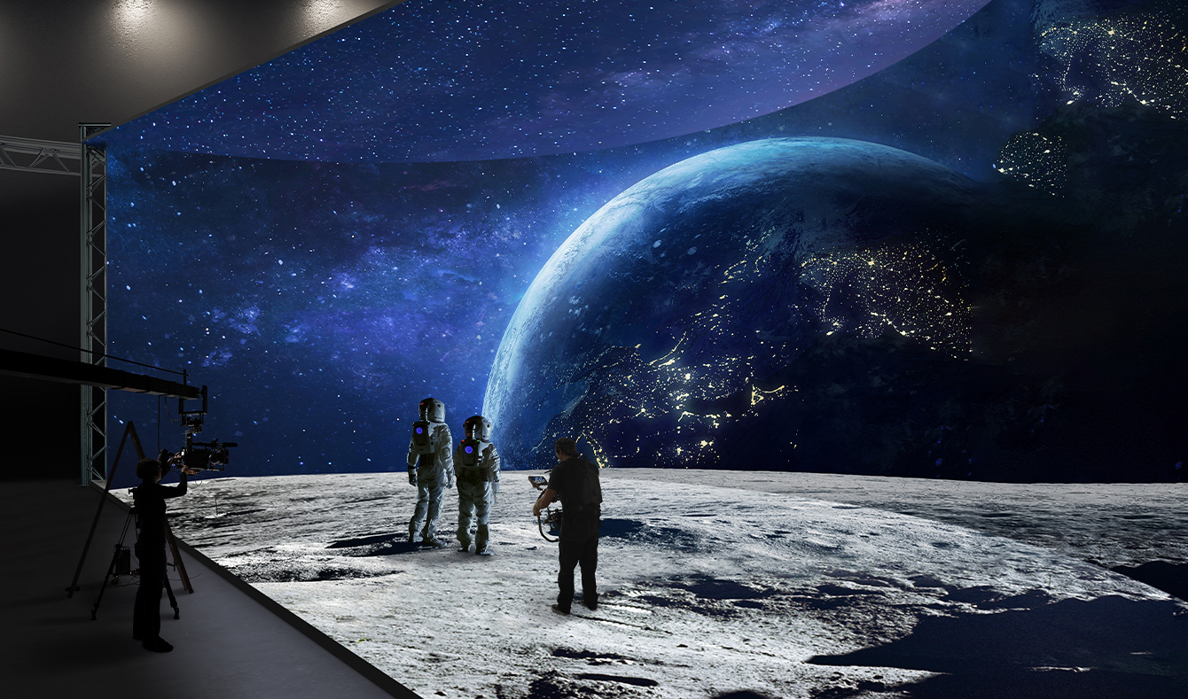A virtual production studio with curved LED walls and ceiling and floor LEDs is filming images of a space landscape.