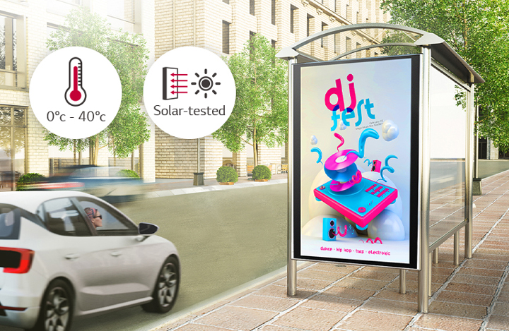 A woman in a car is looking at a DOOH (Digital Out Of Home media) ad on the side of the road. Via a solar test conducted inside LG, this product can operate at wide range of temperature of 0 to 40 degrees.