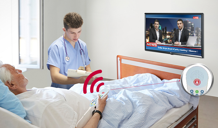 A patient lying in the bed is controlling the TV through a pillow speaker connected to the LN572M.