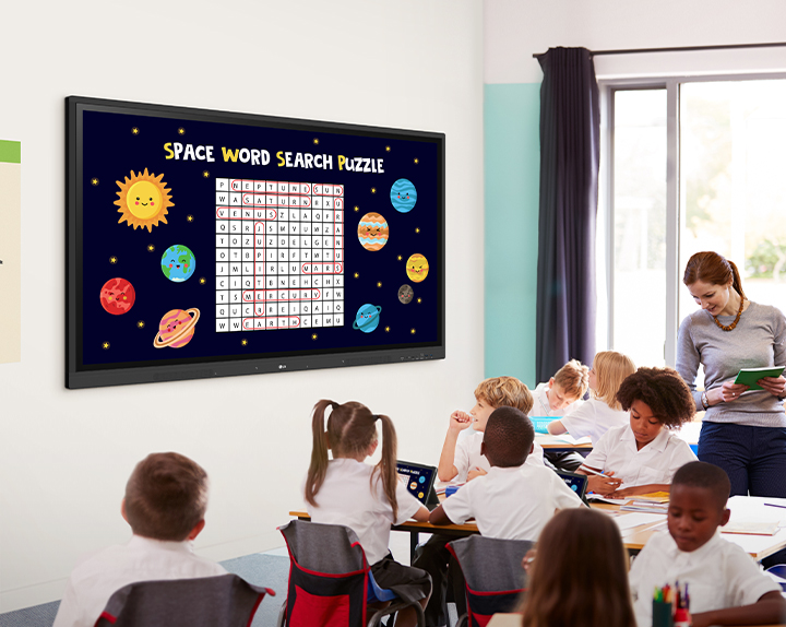 Class is being conducted in the classroom, and the class material screen which is displayed on the classroom wall's LG CreateBoard is being shared on the students' tablets.