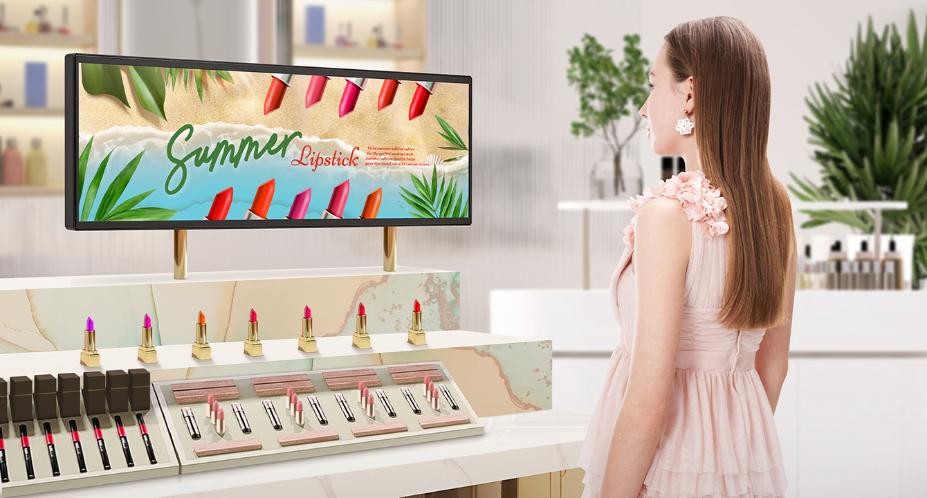 Inside a bright cosmetics store, there is a BH7N installed at the lipstick section. A woman is watching a vivid advertisement displayed on the wide screen of BH7N.