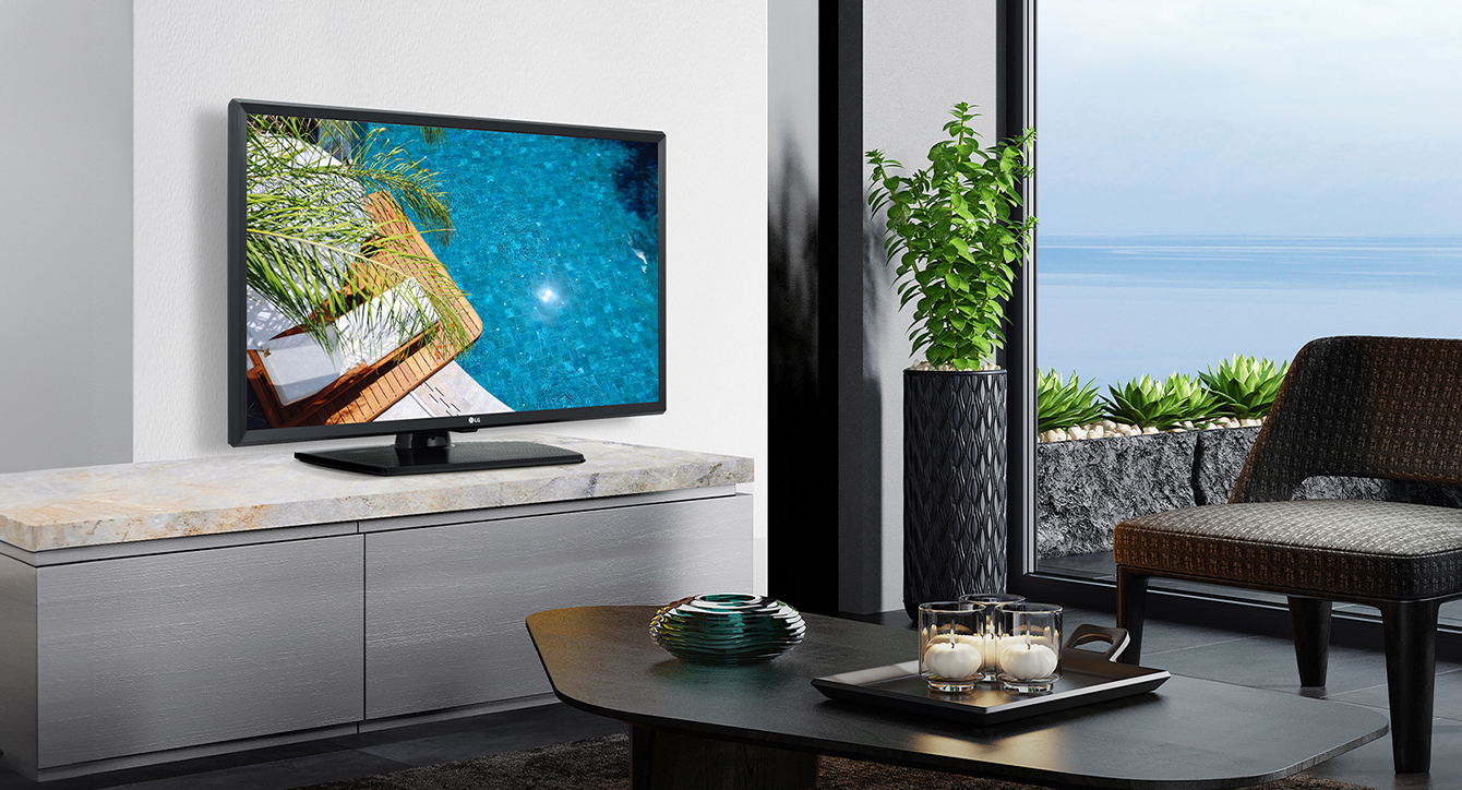 A TV is placed on the wall of the hotel room, and the screen displays a clear view of the hotel swimming pool scenery.