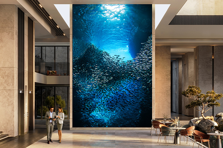 A large, majestic LG MAGNIT is installed in the company lobby, with vibrant underwater landscapes clearly visible on the screen.