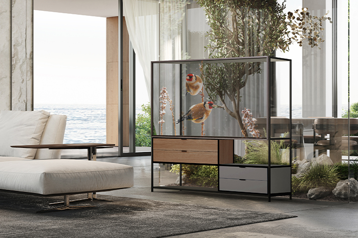 In the living room of a luxurious house with a high floor ocean view, furniture features an integrated transparent OLED display. The screen shows images of birds that blend seamlessly with the large tree visible behind the transparent display.