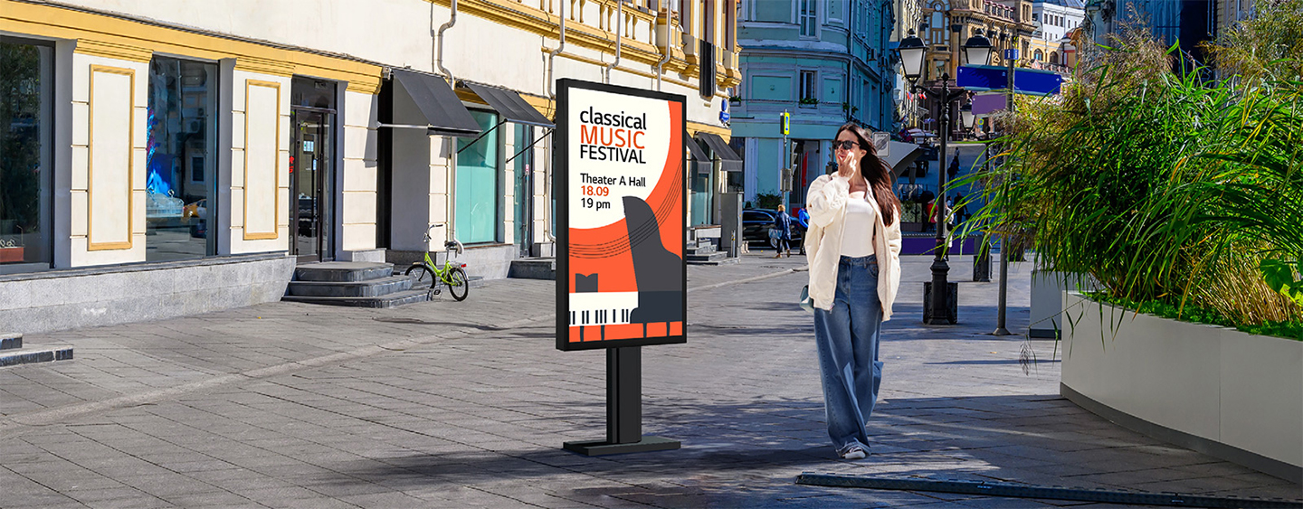 An XE3P is installed on the street, and a woman is looking at a vivid-quality advertisement on the screen.