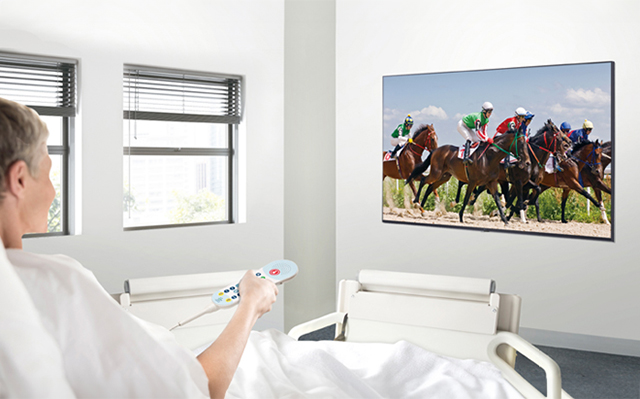 A patient in the hospital room is watching VOD on a TV hanging on the wall without a set-top box.