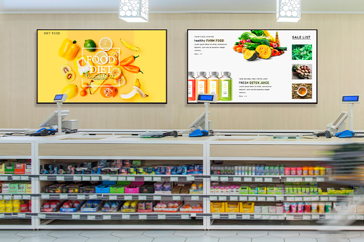 Inside the convenience store, two signage displays are mounted on the wall, each vividly and brightly showcasing advertisements.