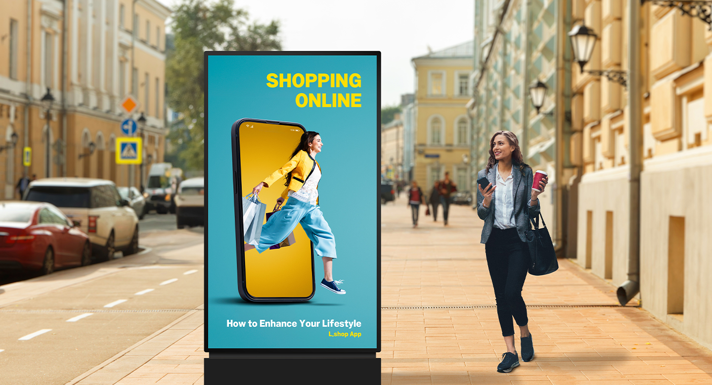 A display as tall as a person is installed on the street, and a woman walking by is watching an advertisement with clear image quality on its screen.